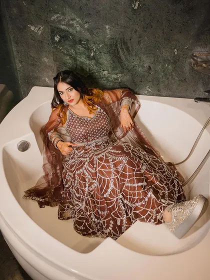 Another bathtub shot, this time with a direct, confident gaze. The contrast between the formal wear and the setting is what makes this shoot stand out.