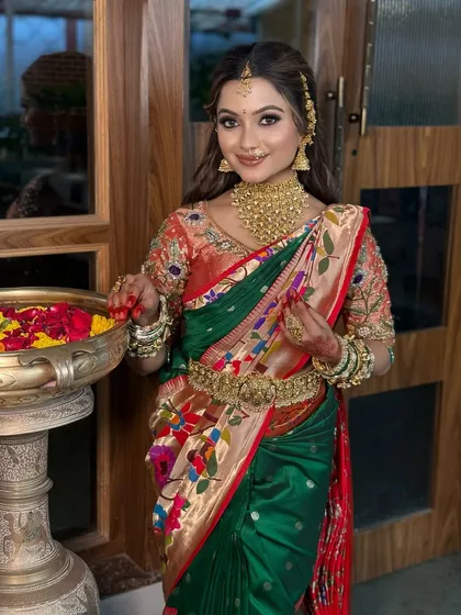 A stunning bride in a multi-colored Paithani saree, featuring a soft glam makeup look and traditional gold accessories.