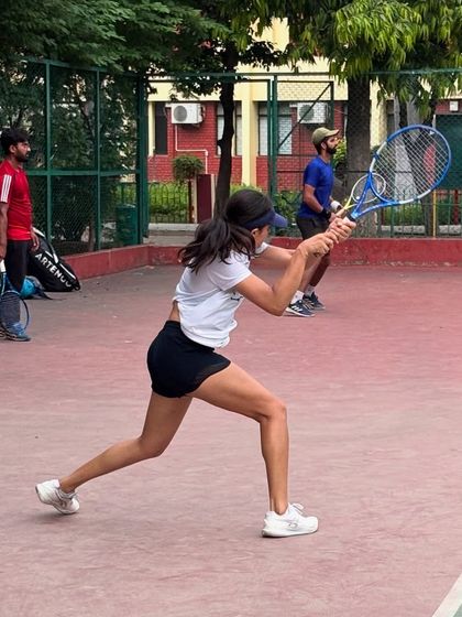 A player hitting a powerful backhand. Our courts are always filled with players who are passionate about improving their game.