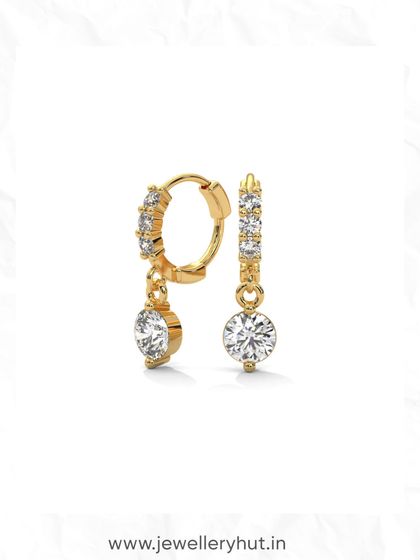 A close-up of our sparkling hoop and drop earrings. The solitaire diamond drop adds a touch of classic elegance to the modern huggie hoop.