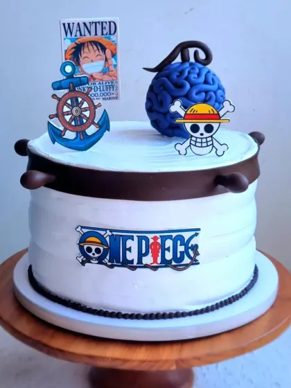 An anime-themed cake for a One Piece fan. This design combines a whipping cream base with a sculpted Devil Fruit and printed edible images for a clean, graphic look.