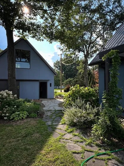 A stone path winds through the garden of our House on Crooked Lake project in Michigan. This shows how our principles of integrating architecture and landscape are applied in a completely different climate and context.