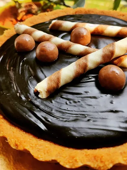 A decadent, homemade, and eggless chocolate tart with a buttery crust and a rich, glossy chocolate ganache filling, perfect for satisfying any sweet craving.