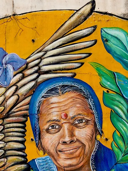 A detailed shot of the woman's face in the Coorg mural. Her warm, knowing smile is the heart of the painting.