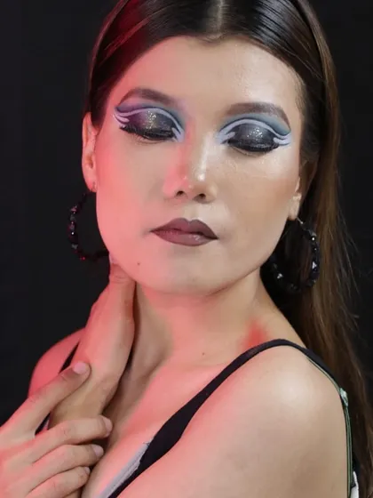 A creative editorial look with a graphic blue and white winged eyeshadow design.