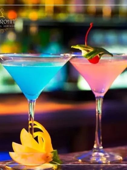 I believe a drink should be a centerpiece of your celebration. Here, two of my custom creations, a vibrant Blue Lagoon and a delicate pink mocktail, are served in classic martini glasses. The presentation, complete with artistic garnishes like a carved starfruit peel and a fresh cherry, reflects my commitment to making every detail perfect for your event.