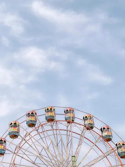 The top of a Ferris wheel against a vast, cloudy sky. This shot uses negative space to create a feeling of openness and freedom.