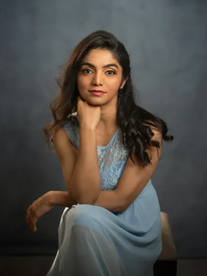 Mridula's portrait is a study in quiet confidence. Seated against a simple, textured backdrop, her direct gaze and relaxed posture convey a sense of self-assurance. The soft lighting highlights her features, creating a classic and elegant fine art portrait.