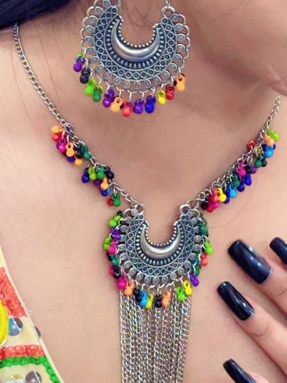 Another view of the multi-colored bead necklace, this one featuring silver chain tassels for extra movement.