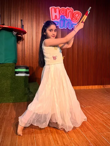 A graceful pose from a student in a lovely white outfit. Each child gets a chance to shine and have their special moments captured during our photo sessions.