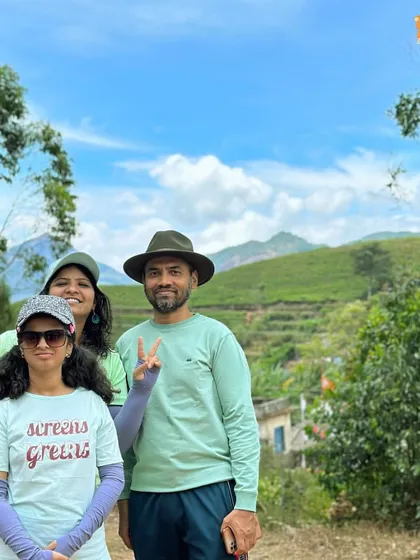 A family enjoying the green landscapes of Munnar. Our trips are designed for all ages.