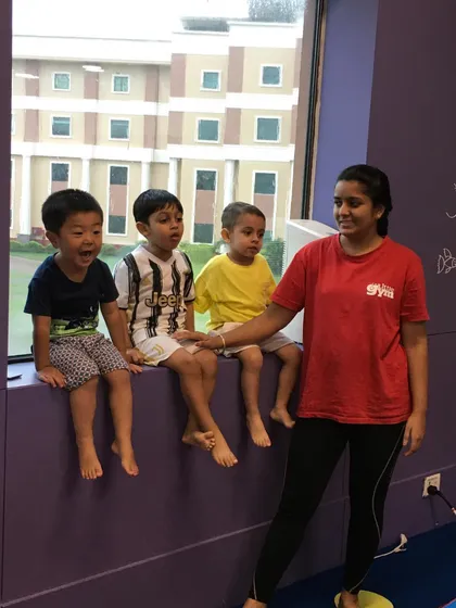 A candid moment of friendship and fun. Three boys sit with their instructor, sharing a laugh and building social connections.