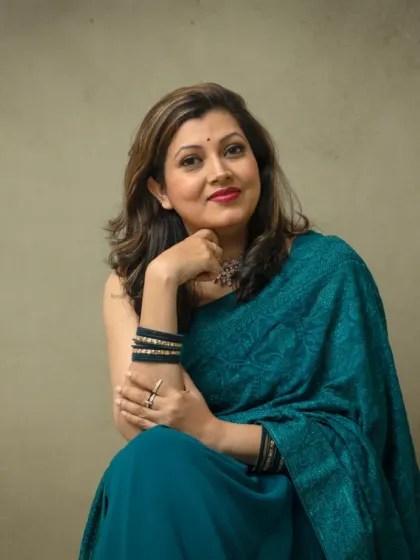 An elegant portrait celebrating personal style. Here, we used a simple, neutral background to let her beautiful teal saree and confident presence shine, creating a timeless and graceful image.