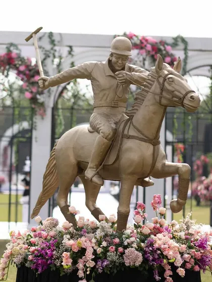 A life-sized statue of a polo player on horseback, surrounded by a bed of flowers. This centerpiece celebrated the theme of the event in a grand and artistic way.