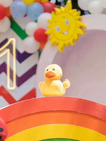 A cute ducky prop perched on a rainbow, adding to the playful and colorful Cocomelon theme.