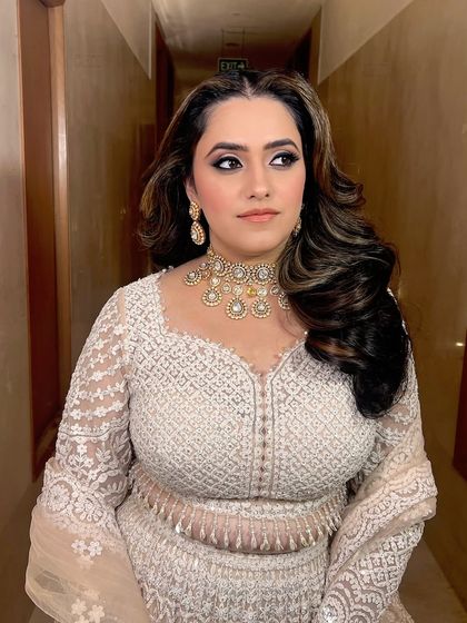 A side profile, showing the beautiful soft waves in her hair and the flawless makeup.