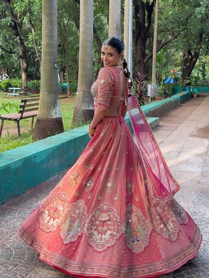 A full view of this stunning modern bridal lehenga. The makeup complements the outfit perfectly without overpowering it, and the mirror-work braid adds a unique touch.