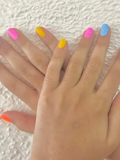 A vibrant and playful manicure perfect for our younger clients. This look features a different bright gel polish on each nail for a fun, rainbow-inspired effect.