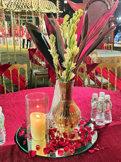 Even the smallest details matter. This table centerpiece combines candles and florals with red accents, tying the entire wedding theme together.