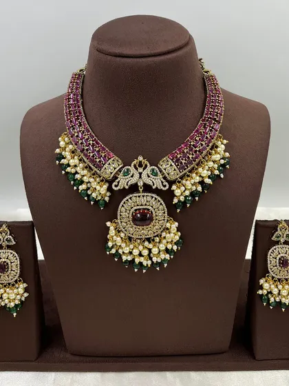 A statement antique necklace set with peacock motifs and a heavy pendant.