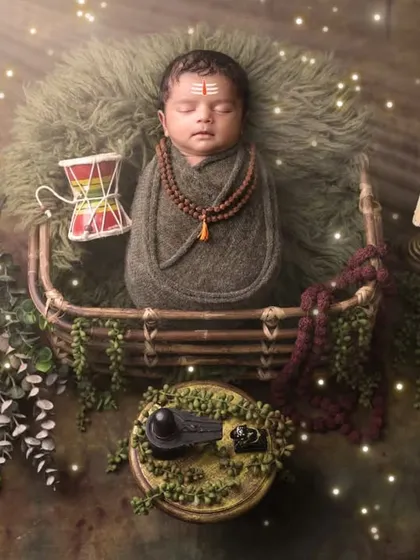 A divine portrait of a baby boy as little Mahadev. Our cultural and mythological themes are created with great attention to detail, featuring custom wraps, props like the damaru and Trishul, and atmospheric lighting.