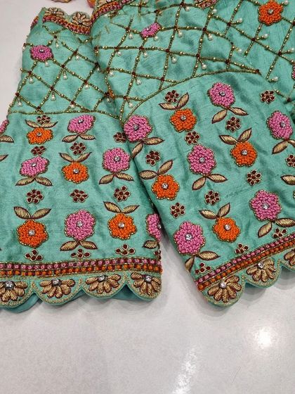 A close-up of the sleeves of the mint green blouse, showing the beautiful floral embroidery that complements the back design.