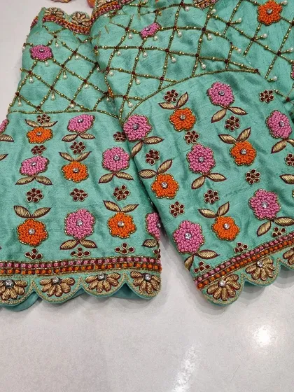 A close-up of the sleeves of the mint green blouse, showing the beautiful floral embroidery that complements the back design.