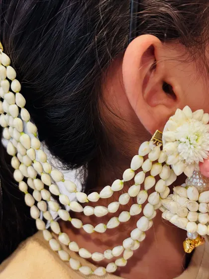A close-up of my handcrafted floral ear chains, or 'kaan-chain'. Made from delicate mogra buds, they add a beautiful traditional element to your look.