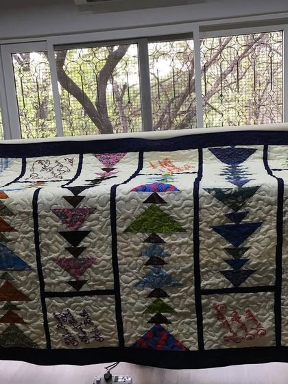 A flying geese quilt on the longarm machine frame.