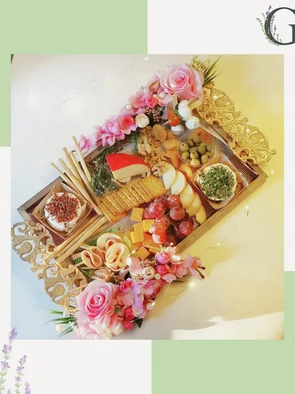 Unbox pure luxury with our gourmet hampers. This image showcases a beautifully arranged gift tray with cheese, crackers, and flowers, perfect for luxury gifting.