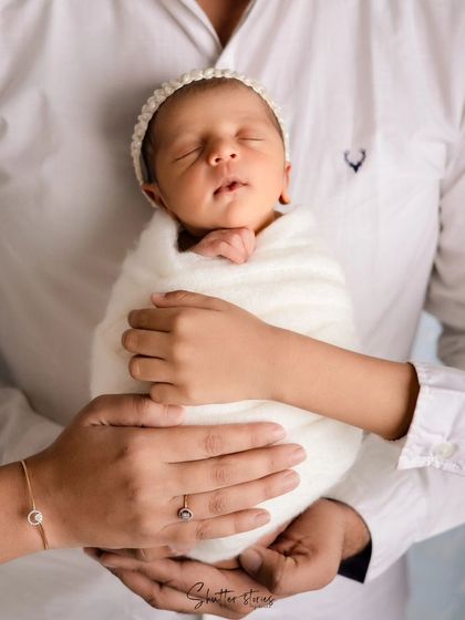 A beautiful family portrait in all white, with a big brother holding his new baby sister. A timeless and classic look.