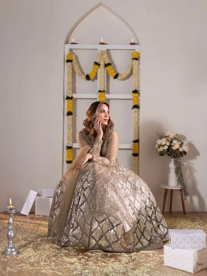 Capturing a candid, smiling moment. The flower petals on the floor and the soft lighting add to the romantic and celebratory feel of this traditional beauty shoot.