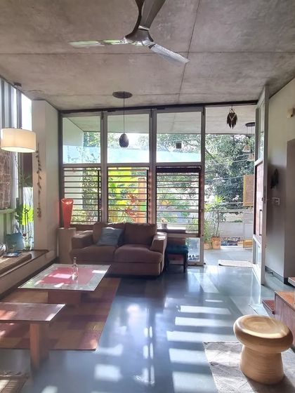 This is my sanctuary. The living space is designed to be open and connected to the small garden outside, with large windows and louvered panels that allow for natural light and cross-ventilation, essential for our tropical climate.