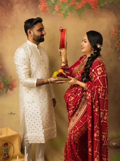 The iconic Karva Chauth ritual captured in a timeless portrait. The wife looks at her husband through the sieve, a moment of devotion and love preserved forever.