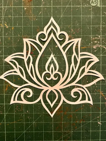 This is what the lotus design looks like right after I've finished cutting and before it goes into a frame. You can see all the delicate connections on my cutting mat. The empty spaces are just as important as the lines I leave behind.