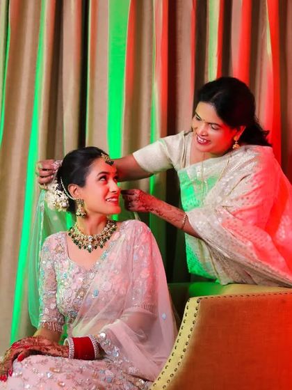 A mother helps her daughter get ready, a touching moment between them.