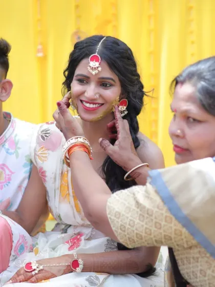 A candid moment from a Haldi ceremony in Rishikesh. The bride's makeup is minimal and radiant, designed to give her a natural glow that shines through the turmeric.