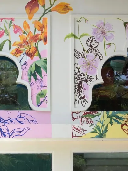 Another detail of the restaurant facade, showing how the floral motifs are integrated with the traditional arched window frames. The mix of styles and colors reflects a modern take on cultural heritage.