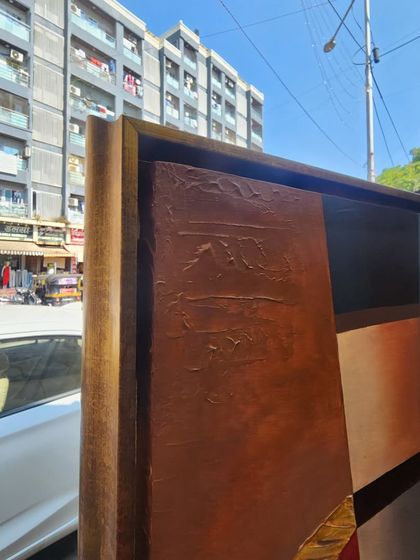 A side view of the large canvas as it's being prepared for transport. You can see the thickness of the frame and the textured details along the edge, giving a sense of the painting's substantial presence.