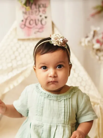 A beautiful, direct portrait of the baby girl in her boho-themed setup. Her serious expression shows a different, equally adorable side of her personality.