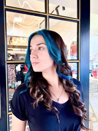 A final look at the blue face-framing highlights. The color is placed perfectly to brighten her features, and the soft waves complete this stylish and modern look.