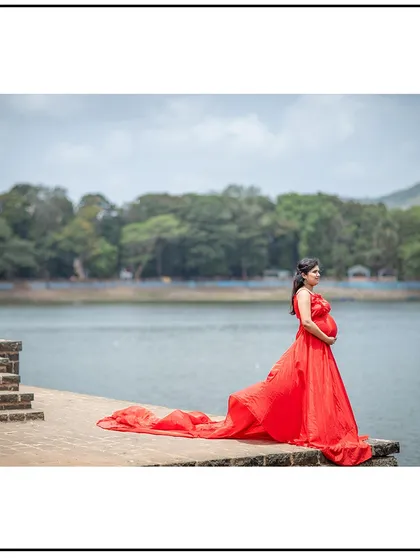 A peaceful solo portrait by the water, with the red gown's train spread out beautifully.