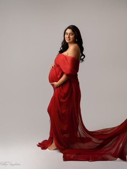 A classic maternity pose in a stunning red gown with a long train. This is a timeless look that always feels powerful.