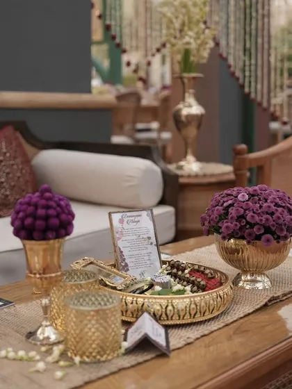 A close-up of a table setting with unique purple flower arrangements and traditional brassware, showcasing my eye for unique color combinations and details.