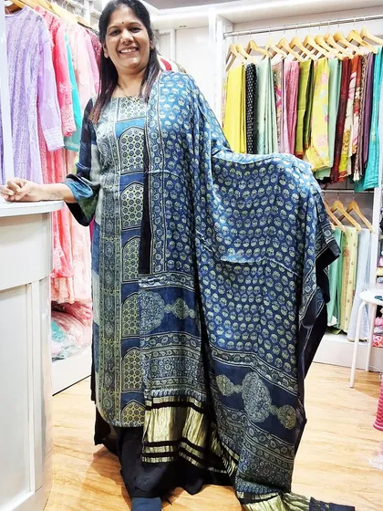A happy customer in our boutique, wearing a custom-stitched kurti made from our modal Ajrakh fabric. Her smile says it all.