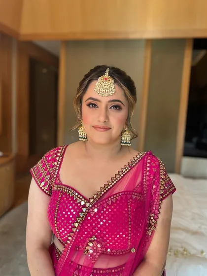 A happy bride, her makeup looking soft and natural for her Mehendi ceremony.