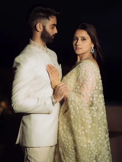 A dramatic, high-fashion pose against a dark background. This shot from a rooftop engagement in Mumbai highlights the couple's stylish outfits and creates a modern, edgy, and cinematic feel.
