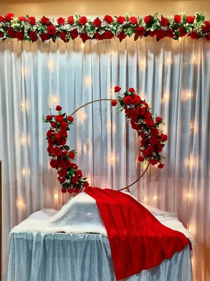 This elegant red and white themed decor is perfect for a home celebration. The design uses a modern floral ring and classic rose arrangements.