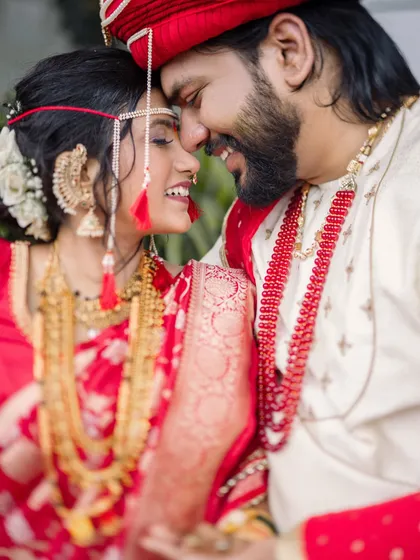 The story is in the small, silent conversations. This candid photograph captures the pure joy and intimacy of a newly married couple, focusing on their smiles and the gentle touch that says everything. It's a perfect moment from a beautiful Maharashtrian wedding.