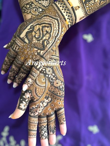 A close-up of the back of the hand, with a swirling peacock design and floral details.